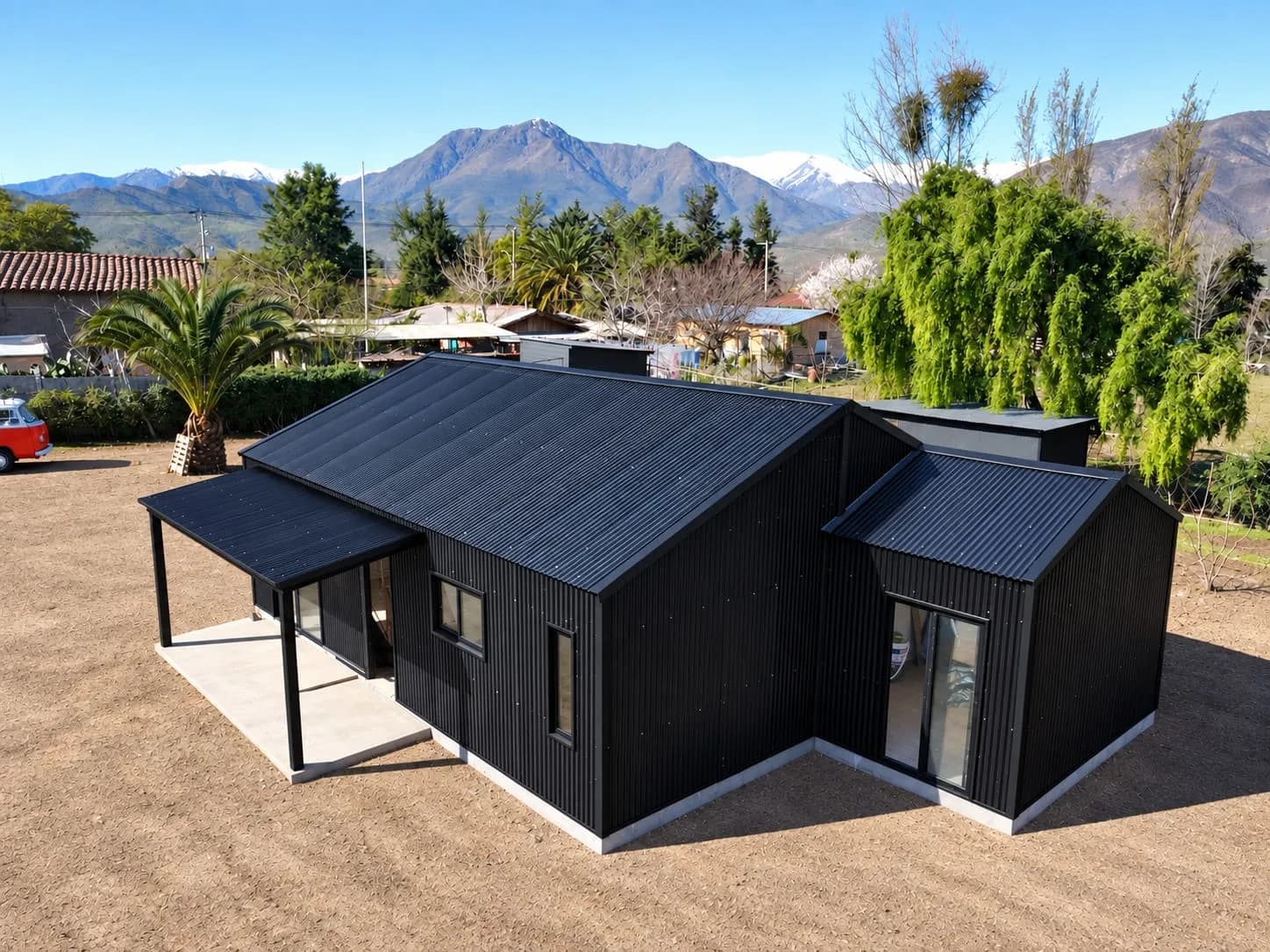 Casa con revestimiento metálico negro construida por Vergara & Cordero frente a la cordillera